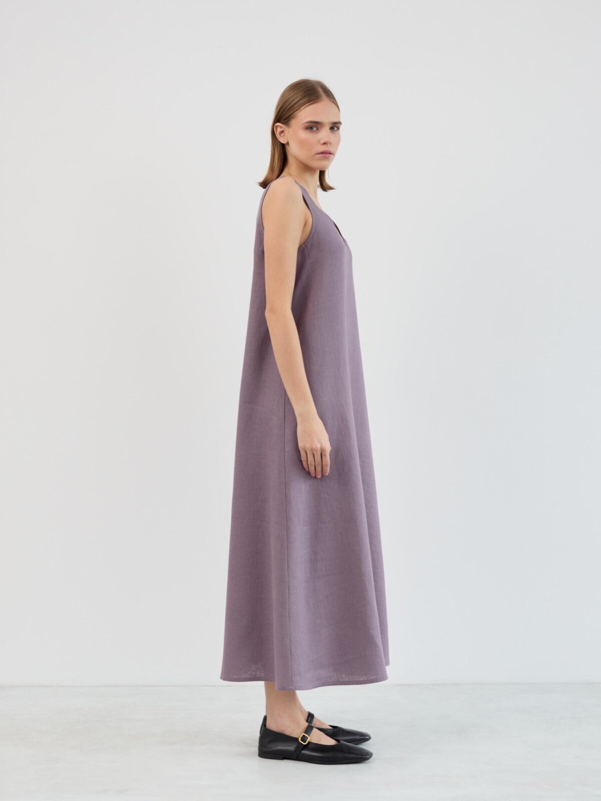 Side profile of the Lanav sleeveless linen maxi dress in lavender violet, showing the gradual A-line flare from shoulder to hem